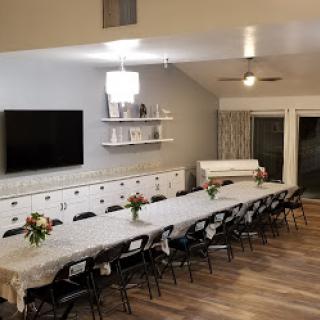 A spacious dining area set with a long table and elegant floral arrangements, perfect for gatherings.