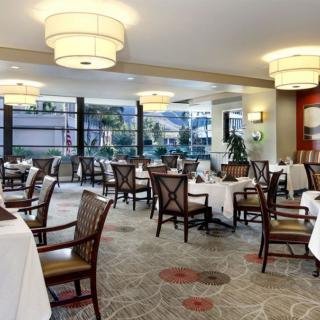 An elegant dining area with neatly arranged tables and chairs, featuring warm lighting and tasteful decor.