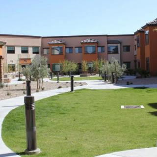A tranquil courtyard surrounded by modern buildings with green grass and pathways.