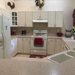 A neatly organized kitchen with white cabinets and modern appliances.