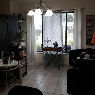 Cozy living room with a window view, plants, and comfortable seating.