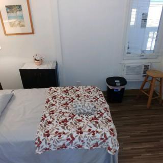 A cozy massage room with a therapy table covered in a floral blanket.