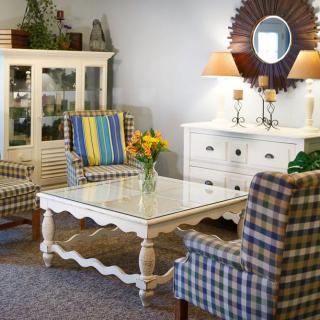 A cozy living room featuring a white coffee table, patterned armchairs, and elegant decor with warm lighting.