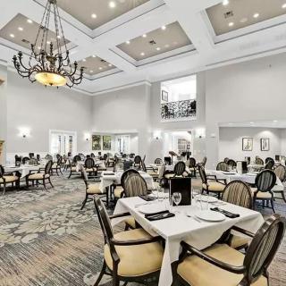 An elegant dining room with chandeliers and neatly set tables.