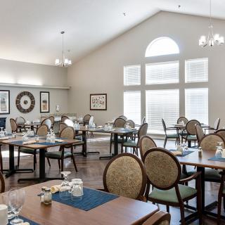 A well-lit dining area with neatly arranged tables and chairs.