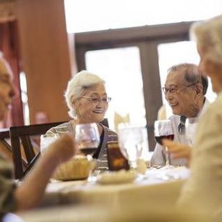 A group of elderly friends enjoying a meal together at a restaurant.