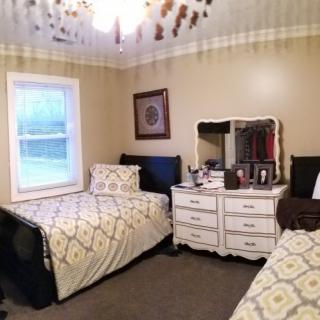 A cozy bedroom with twin beds and a dresser with a mirror.