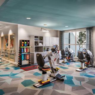 A modern gym with exercise equipment and bright, colorful decor.