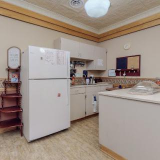 A cozy kitchen with a refrigerator, countertop, and cabinets.