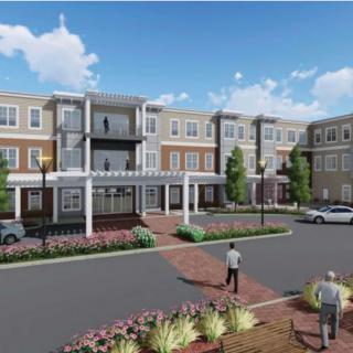 A modern residential complex with well-maintained landscaping and a spacious parking area.