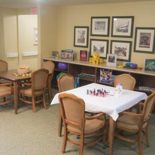 A cozy dining area with tables and chairs, decorated with artwork on the walls.