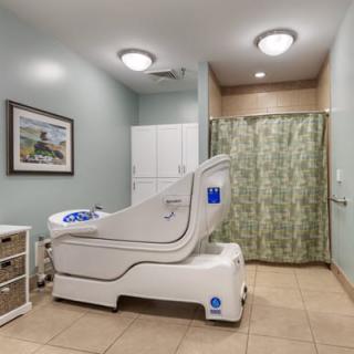 A healthcare facility room featuring an accessible bathtub designed for patient care.