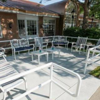 A cozy outdoor patio with metal furniture arranged in a circle, perfect for gatherings.
