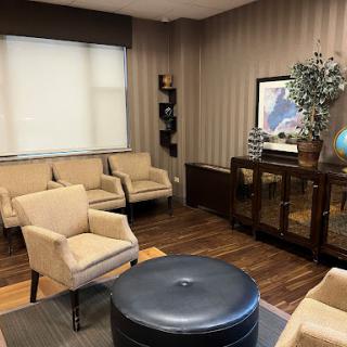 A cozy waiting room featuring modern furnishings and a warm color palette.