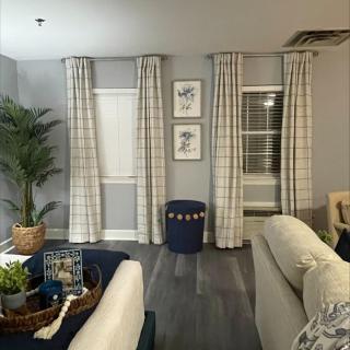 A cozy living room with checkered curtains and modern decor.