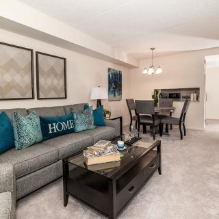 A modern living room with a dining area, featuring a comfortable sofa and stylish decor.