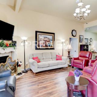 A cozy living room with comfortable seating, a mounted television, and elegant decor.