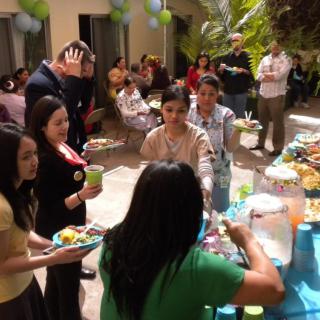 A group of people enjoying food and drinks at an outdoor gathering.