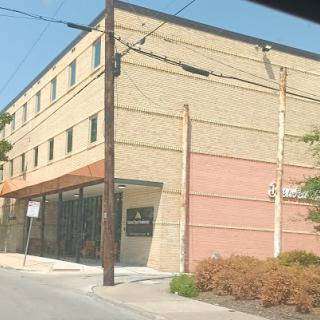 A view of a three-story commercial building with a brick facade in an urban setting.