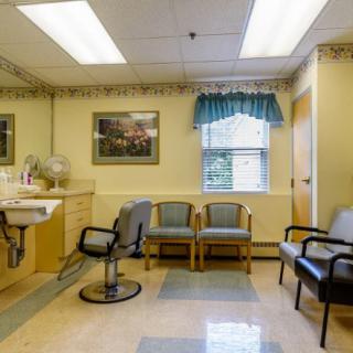 A well-lit waiting room with several chairs and a window.