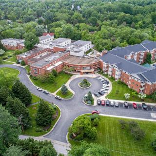 Aerial view of a large building complex surrounded by greenery.