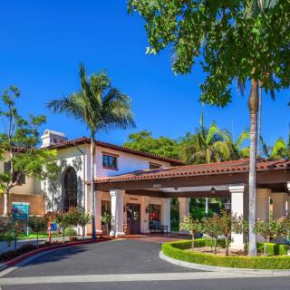 A luxurious resort entrance surrounded by palm trees and lush landscaping.