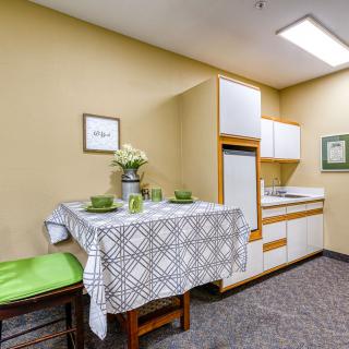 A small kitchenette with a dining area featuring a table and chairs.