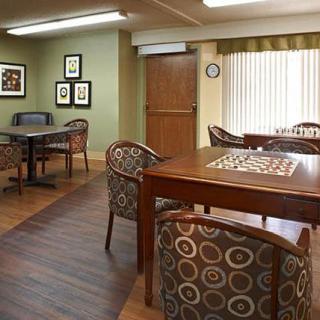 A cozy room with wooden tables and patterned chairs, featuring a warm interior decor.