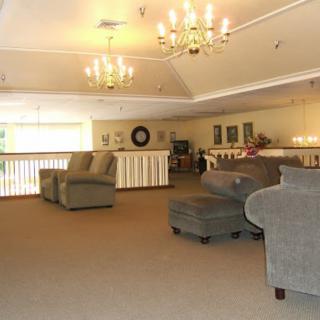 A spacious lounge area with comfortable seating and elegant chandeliers.