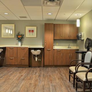 A cozy and well-decorated waiting room in a medical facility, featuring comfortable seating and modern cabinetry.