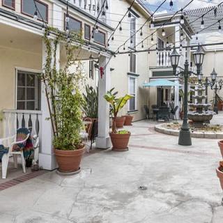 A charming courtyard with a central fountain, surrounded by potted plants and outdoor seating.
