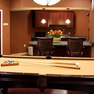 A cozy game room featuring a billiards table and a stylish bar area.