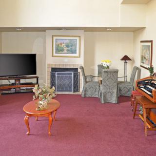 A cozy living room with a television, fireplace, and various furniture pieces.