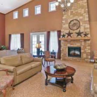 A spacious living room with a stone fireplace and elegant decor.