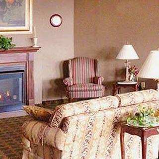 A cozy living room with a fireplace, armchair, and patterned sofa.