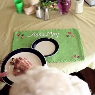 A charming table setting featuring a personalized green placemat with 'Linda Mary', ready for a meal.