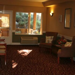 A cozy living room with comfortable seating, warm lighting, and large windows overlooking a scenic view.