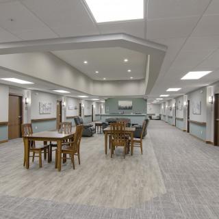 A spacious hallway with tables and chairs arranged for social or work activities.