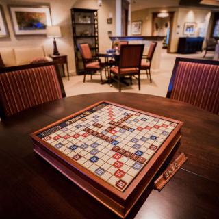 A cozy living room featuring a Scrabble board game set up on a wooden table, ready for play.