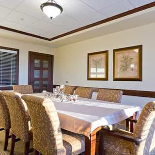 A well-lit dining room with an elegantly set table and comfortable chairs.