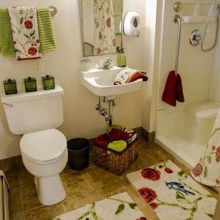 A cozy bathroom with floral decor and a well-organized setup.