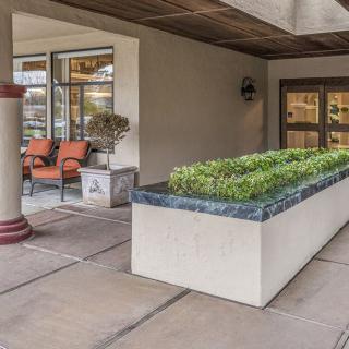 A welcoming outdoor entrance featuring cozy seating and a decorative planter.