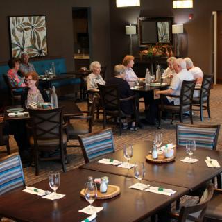 A group of seniors dining at a restaurant with well-arranged tables and comfortable seating.