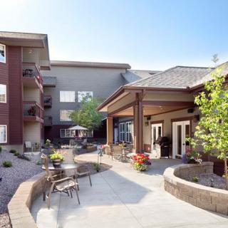 A modern courtyard with outdoor seating and landscaping on a sunny day.