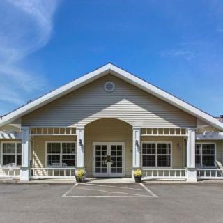 A symmetrical building with a prominent entryway against a clear blue sky.
