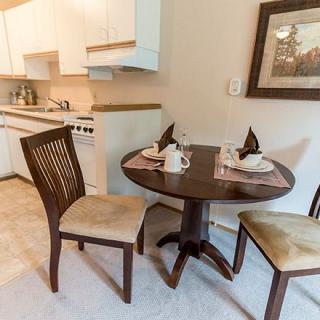 A cozy dining area with a small round table set for two in a kitchen space.