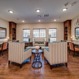 A cozy living room with comfortable seating, bookshelves, and natural lighting.