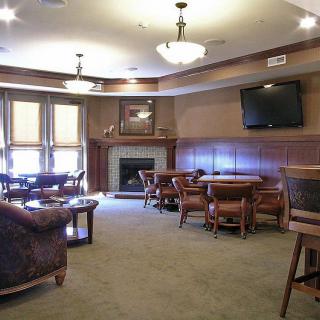 A cozy lounge area featuring comfortable seating, a fireplace, and a mounted television.
