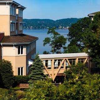 Scenic view of buildings and a bridge overlooking a tranquil lake surrounded by trees.
