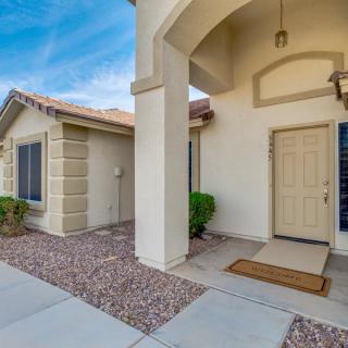 A welcoming entrance to a modern suburban house with a porch and neatly maintained landscaping.